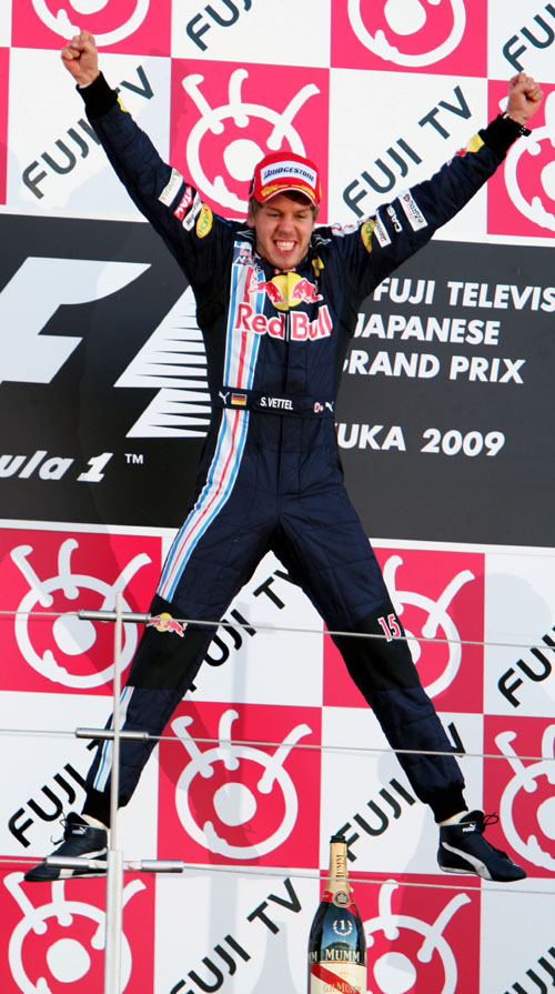 Race winner Sebastian Vettel leaps for joy on the podium