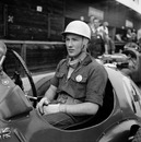 A young and rather pensive Stirling Moss sits in his HWM-Alta before practice