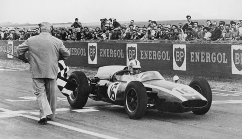 Jack Brabham takes the chequered flag to win