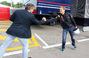 Sebastian Vettel is greeted by Carlos Sainz as he arrives at the circuit