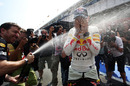Sebastian Vettel is sprayed with champagne by a delighted Red Bull mechanic
