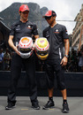 Jenson Button and Lewis Hamilton pose with their diamond-encrusted helmets 
