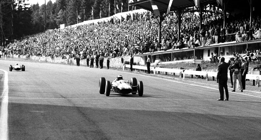 Jim Clark takes the chequered flag after passing the coasting Bruce McLaren