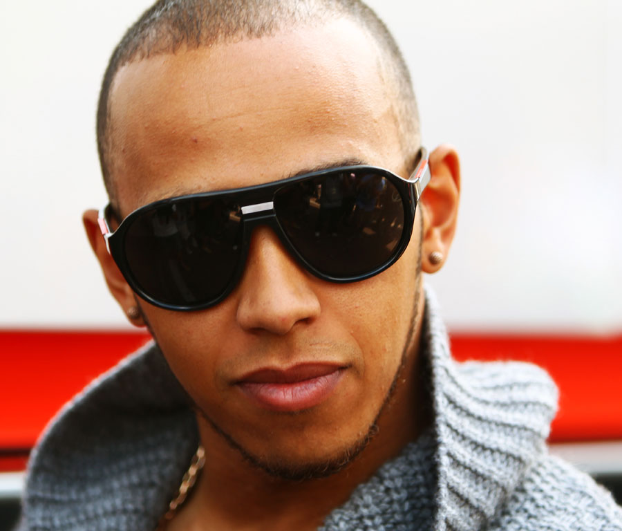 Lewis Hamilton poses for the cameras during a photoshoot
