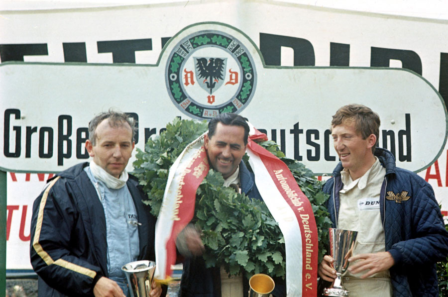 Jack Brabham celebrates his victory on the podium with John Surtees and Jochen Rindt