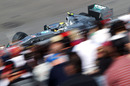 Nico Rosberg flashes past fans in the grandstand