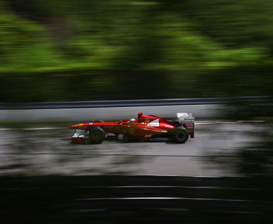 Fernando Alonso flashes through the tree-lined straights of Montreal