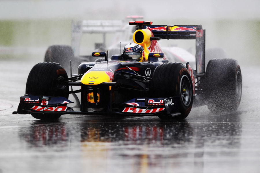 Sebastian Vettel splashes through the standing water
