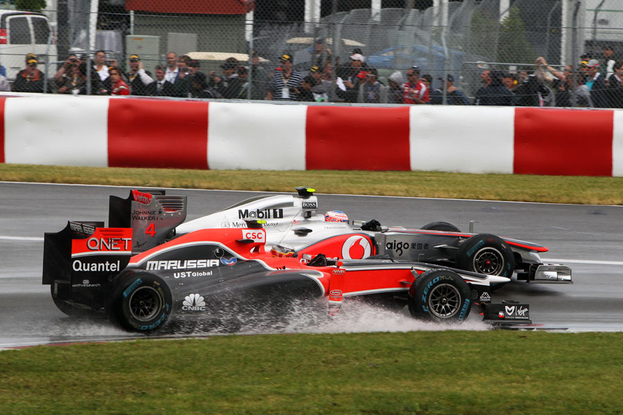 Jenson Button goes round the outside of Jerome d'Ambrosio