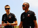 Lewis Hamilton walks through the paddock with his trainer
