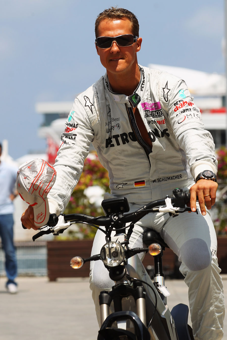 Michael Schumacher rides through the paddock on his bike