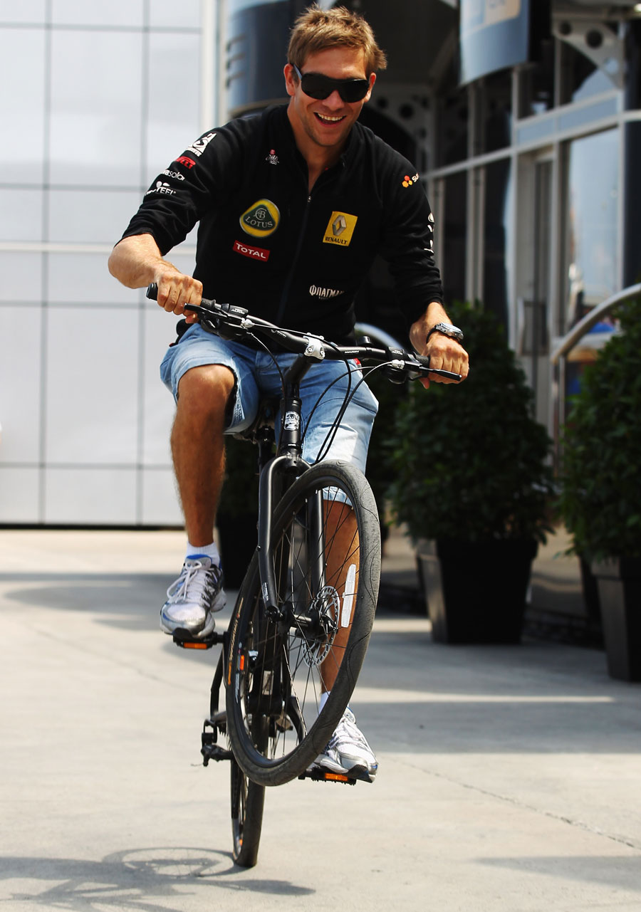 Vitaly Petrov pulls a wheelie in the paddock