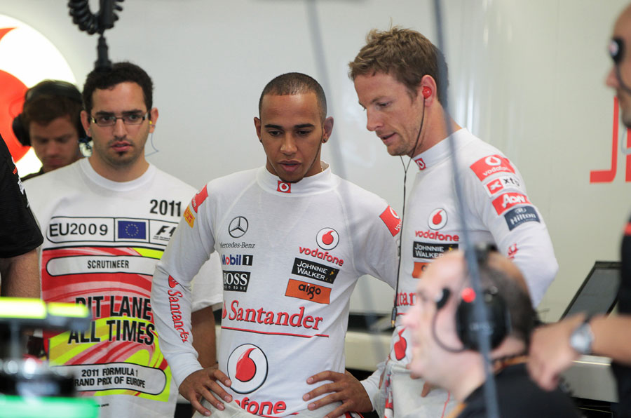 Jenson Button and Lewis Hamilton chat in the McLaren garage
