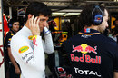 Mark Webber covers his ears in the Red Bull garage