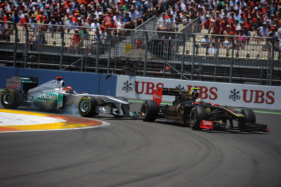 Michael Schumacher clips his front wing against Vitaly Petrov's Renault