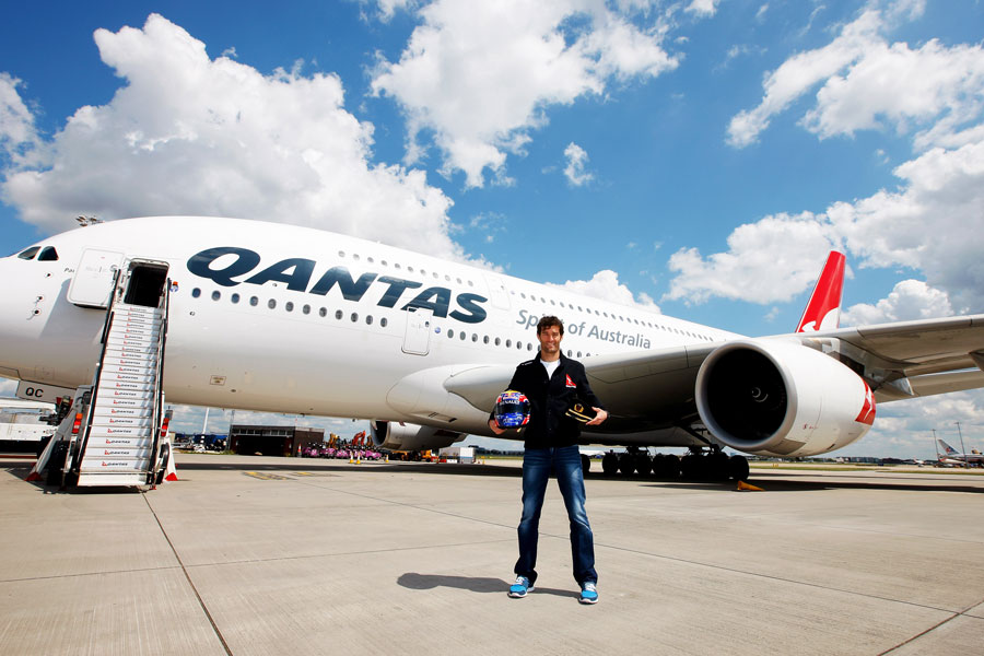 Mark Webber poses for a photo in front of an Airbus A380 after an announcement that he will train to become a pilot with the help of Qantas