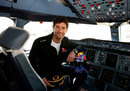 Mark Webber poses for a photo in the cockpit of an Airbus A380 after an announcement that he will train to become a pilot with the help of Qantas