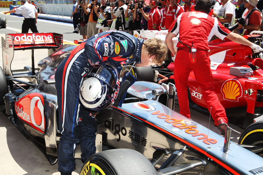 Sebastian Vettel inspects the cockpit of Lewis Hamilton's McLaren