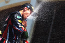 Sebastian Vettel celebrates with a bottle of champagne on the podium