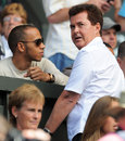 Lewis Hamilton chats with manager Simon Fuller on Centre Court at Wimbledon