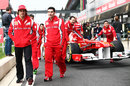 Fernando Alonso walks down the pit lane as his Ferrari is taken to scrutineering