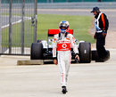 Jenson Button walks away from his McLaren after the botched tyre change which ended his race
