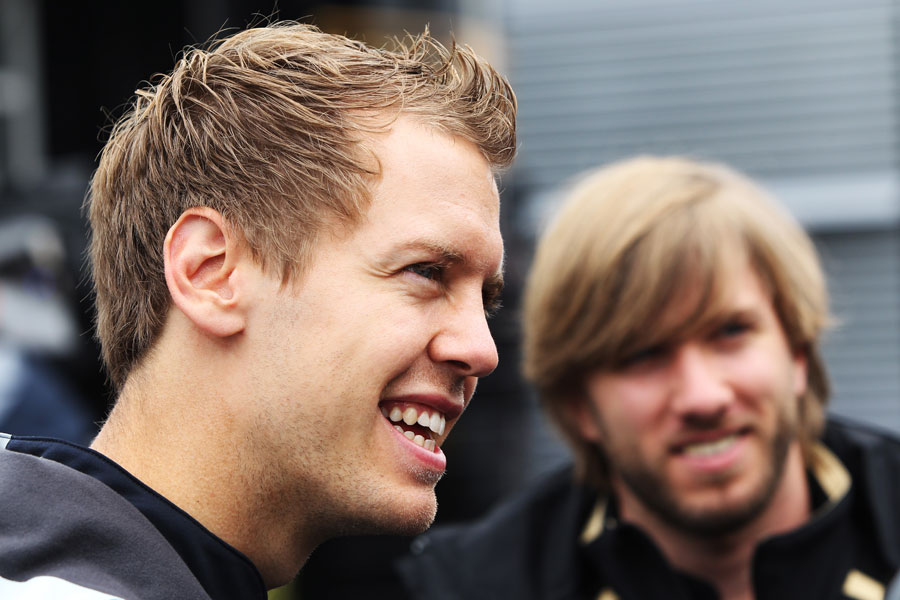 German drivers Sebastian Vettel and Nick Heidfeld joke in the paddock on Thursday morning