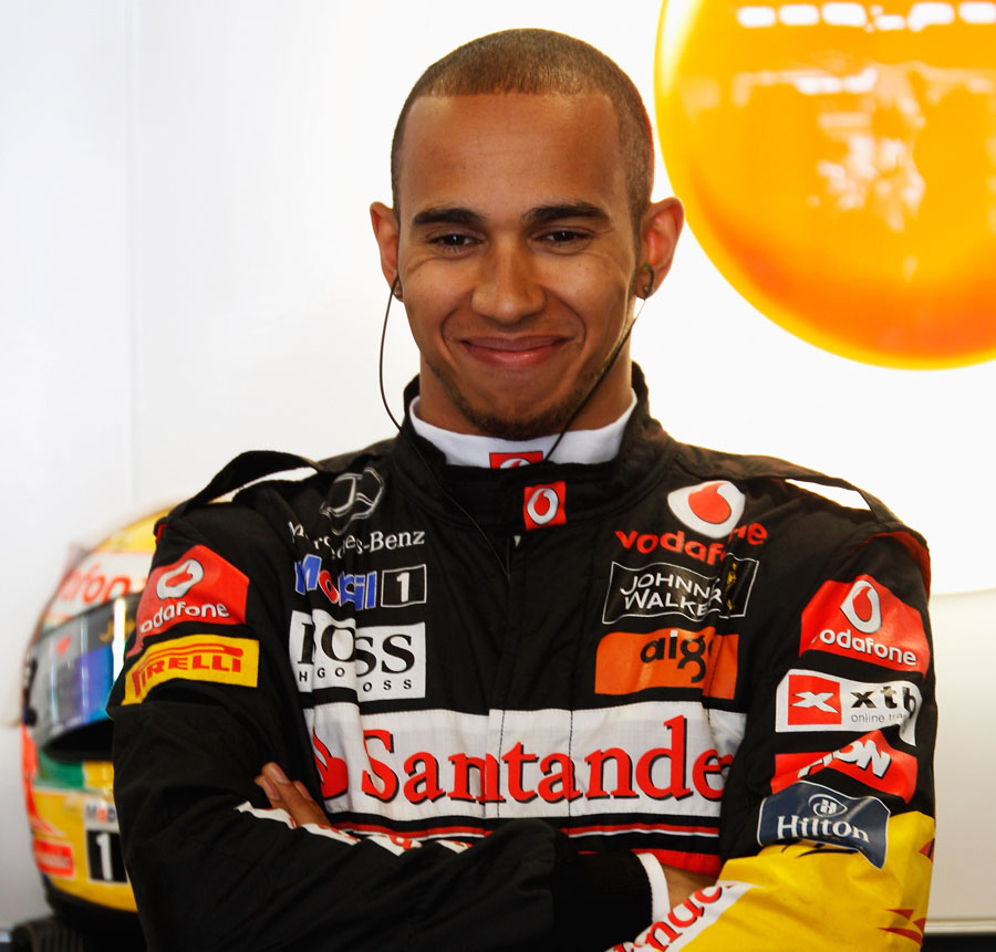 Lewis Hamilton smiles at the back of the McLaren garage