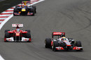 Lewis Hamilton defends from Fernando Alonso, with Mark Webber trying to keep pace