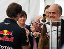Bernie Ecclestone helps himself to some lunch while talking on the phone
