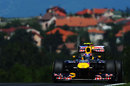 Mark Webber crests the brow of a hill in his Red Bull