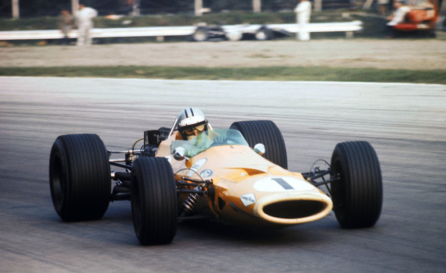 Denny Hulme passes a stricken car on the outside of Parabolica
