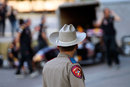  A Texas state trooper looks on as David Coulthard prepares to drive the Red Bull Show Car in front of the Texas Capitol building in Austin