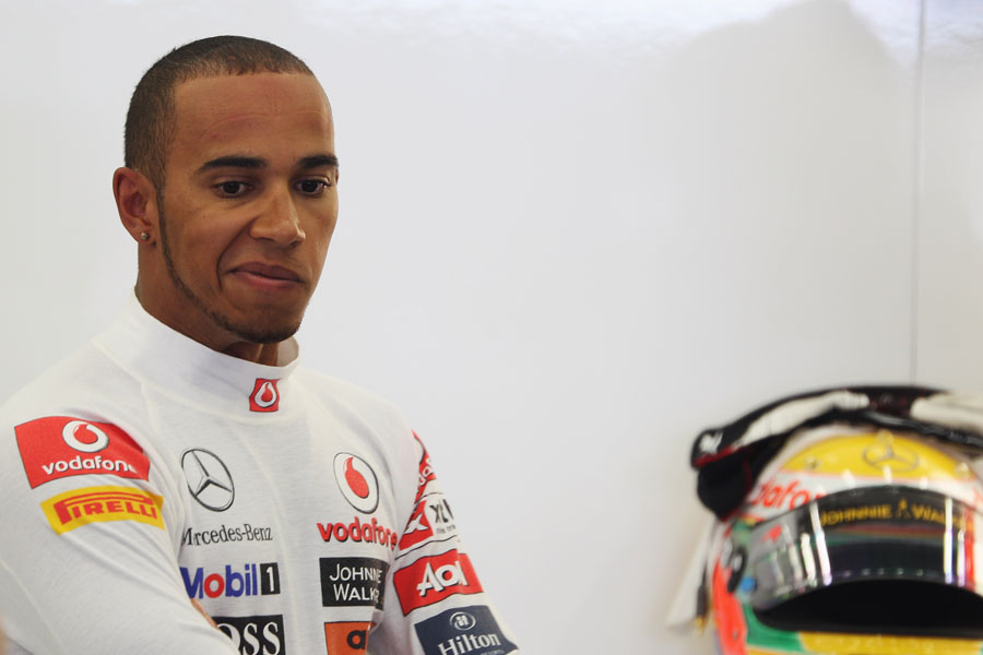 Lewis Hamilton waits for the rain to stop
