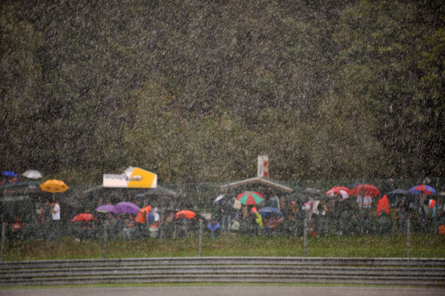 Fans shelter from the heavy rain