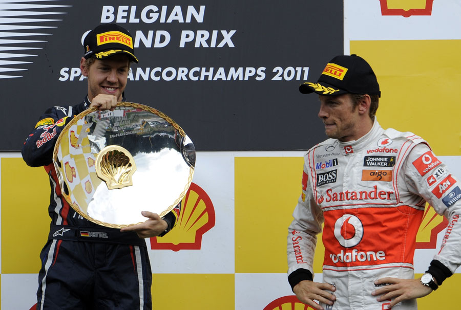 Sebastian Vettel celebrates as Jenson Button looks on