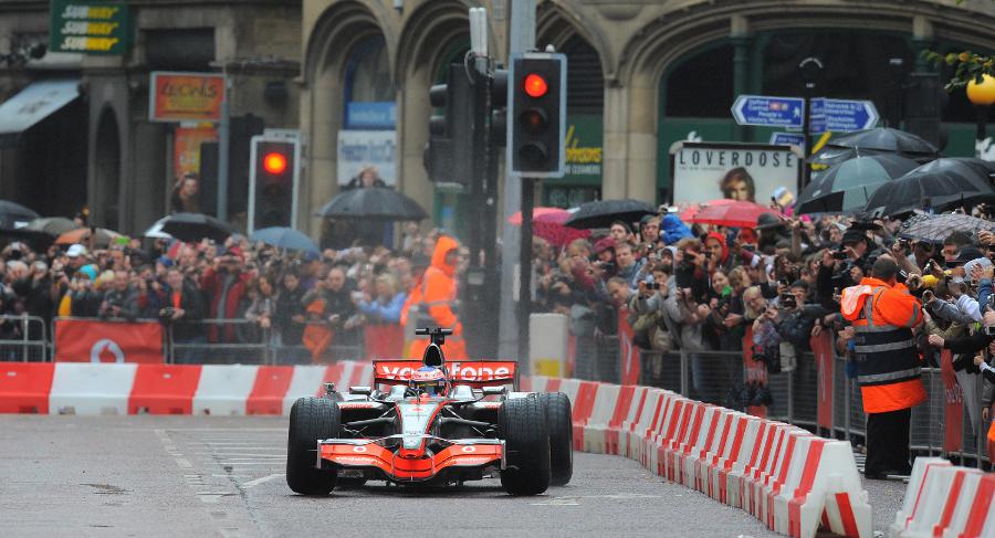 Jenson Button gets the power down on the wet streets during his demonstration run