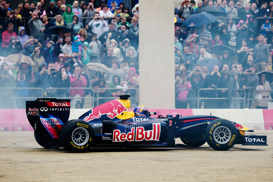 Mark Webber does donuts for the fans after driving his Red Bull F1 car through the city streets of Cardiff