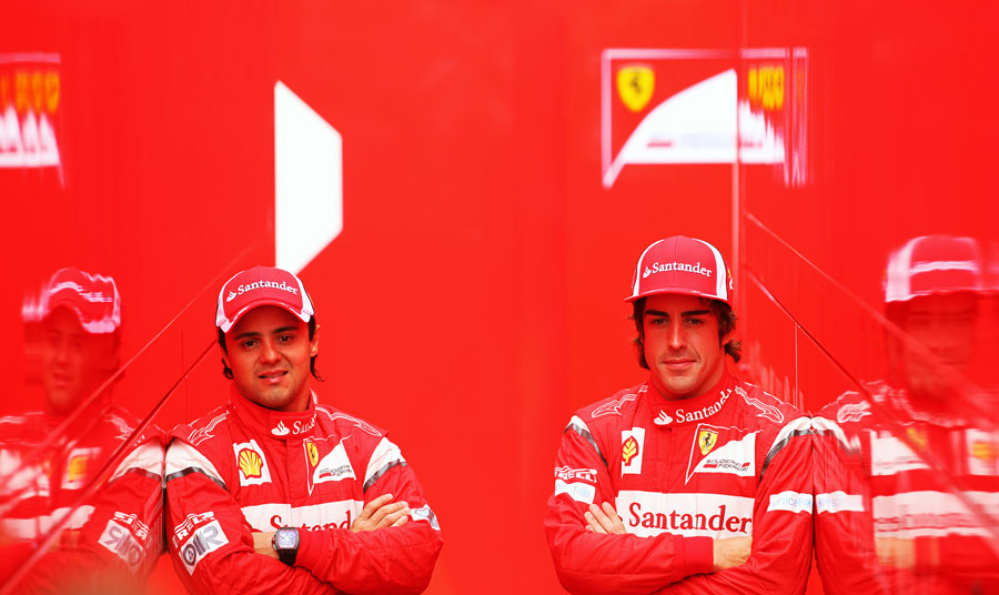 Felipe Massa and Fernando Alonso pose between Ferrari trucks