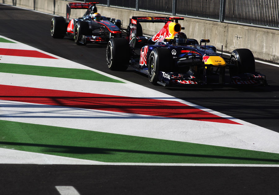 Sebastian Vettel leads Lewis Hamilton in to the pit lane