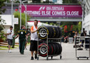 A Force India mechanic wheels tyres through the paddock