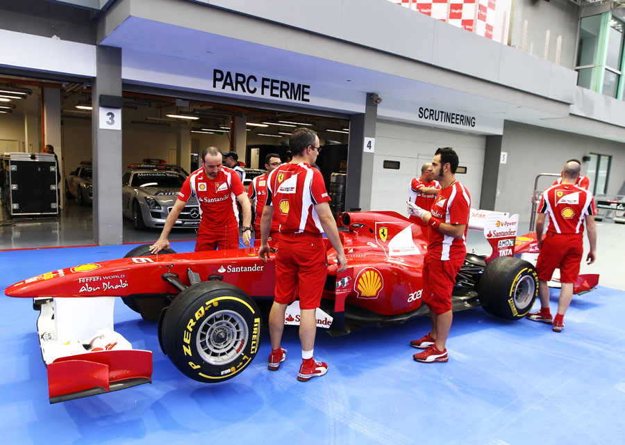 Ferrari mechanics wait outside scrutineering with the F150th 