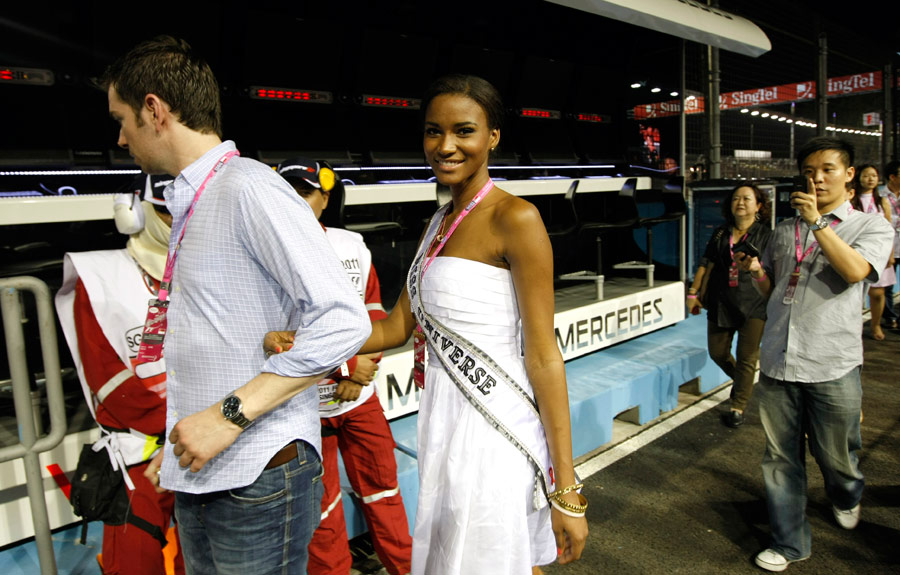 Leila Lopes of Angola, Miss Universe 2011, is led on a tour of the pit lane