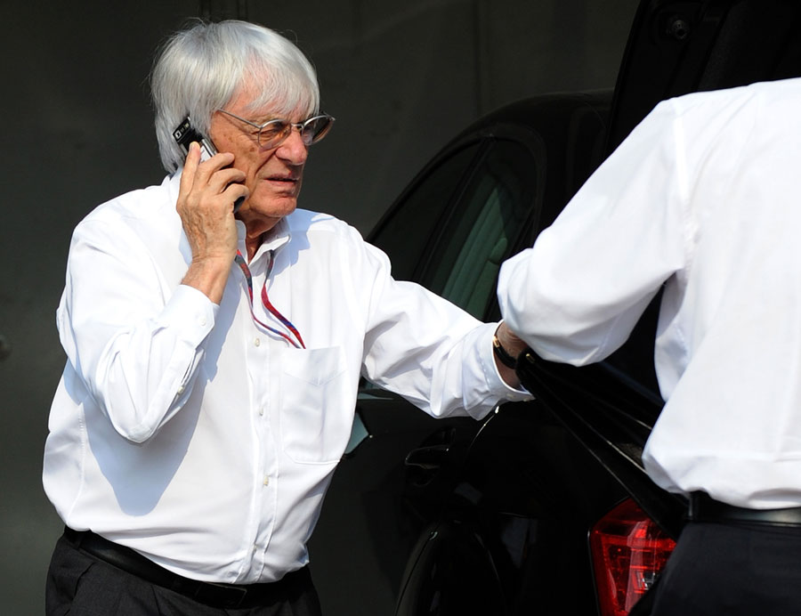 Bernie Ecclestone answers a call on his way to the paddock