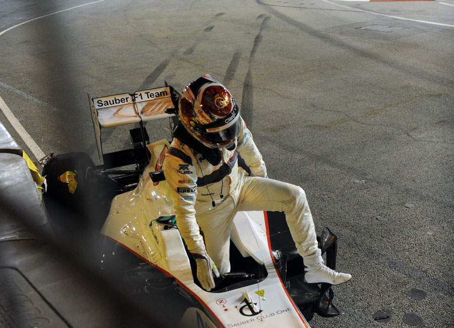 Kamui Kobayashi clambers out of his wrecked Sauber