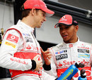 Jenson Button and Lewis Hamilton chat during a photoshoot