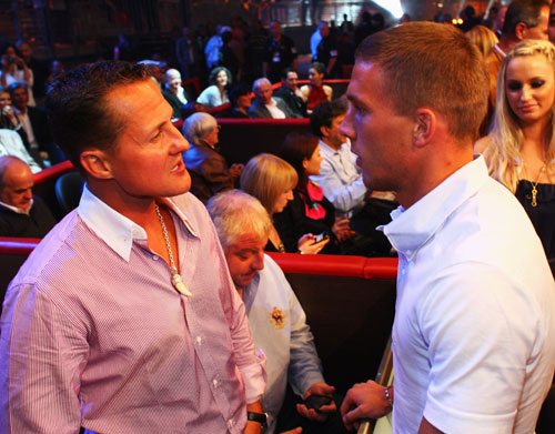 German footballer Lukas Podolski speaks to Michael Schumacher