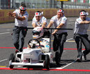 Kamui Kobayashi takes part in a soapbox race down the Suzuka pit straight