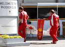 Ferrari mechanics carry a nose cone through the paddock