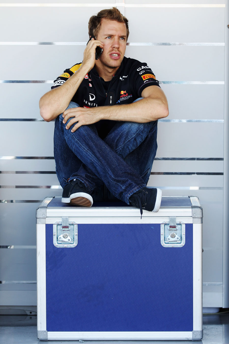Sebastian Vettel makes a phone call in the paddock